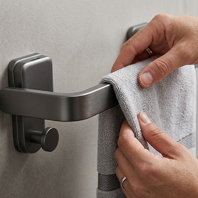 Porte serviette salle de bain mains sur serviette près de la fixation